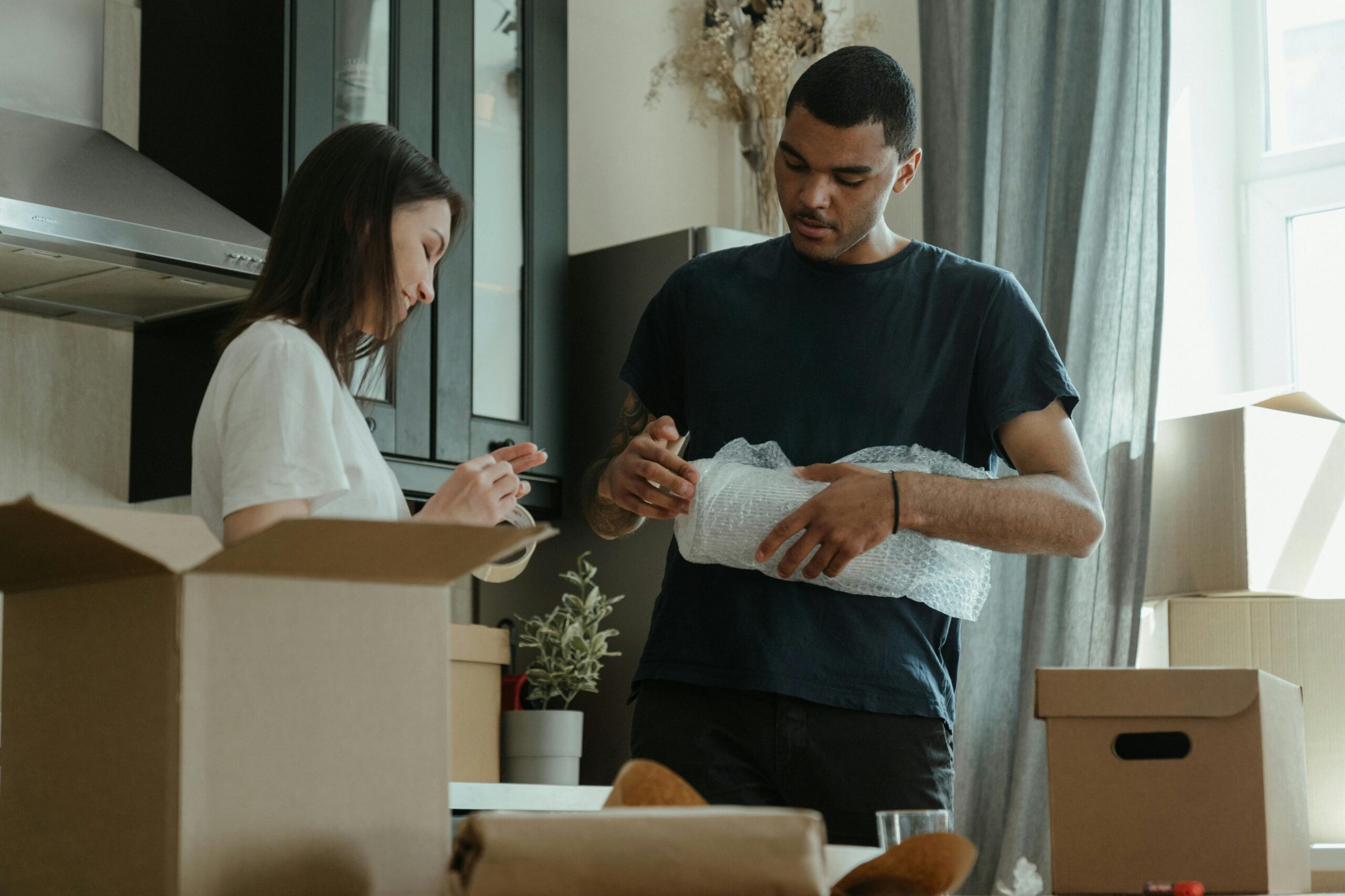 A young couple unpacking boxes together, settling into their new apartment.